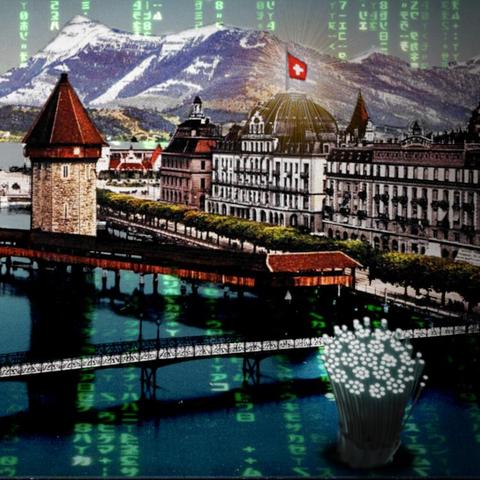 A vintage idyllic picture-postcard view of Lucerne, Switzerland; it features an impressive lakeside building and two elegant span bridges, with snow-capped Alps in the background. The image has been altered: a 'code waterfall' effect (as seen in the credit sequences of the Wachowskis' 'Matrix' movies) cascades down over the mountains and streaks across the water of the lake. Three massive fiber optic bundles rear up out of the harbor, their cut tips glowing white. The Swiss flag atop the lakeside building is haloed with radiant glowing streaks.