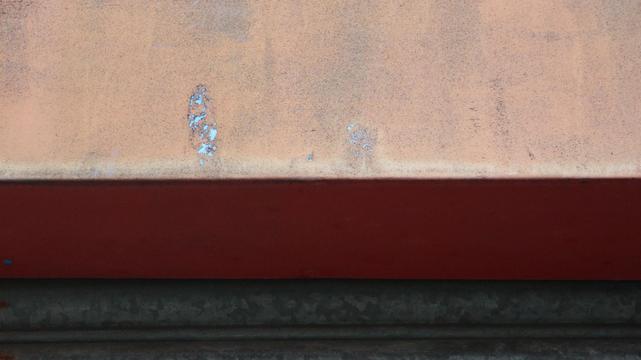 pink, red and grey levels to a wall - with a bright green shining through