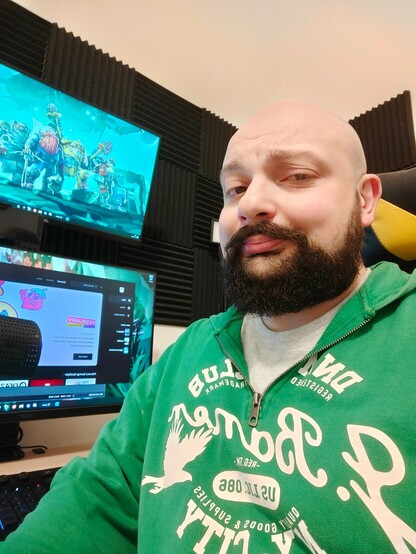 A bald and bearded dude giving you a smirk
