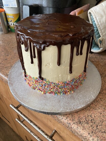 Picture of a drip cake with a ganache drip and sprinkles at the base. 