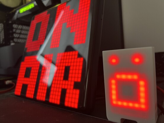 An LCD frame that says “On Air” in red lettering, with a small LCD screened robot next to it with a screaming face. Which it does every time it sees my face. 