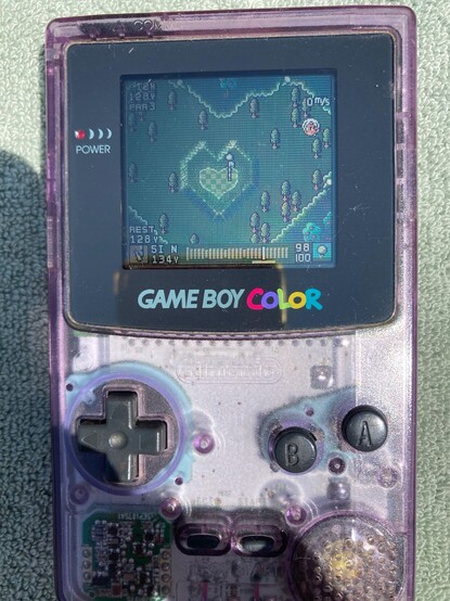 Image of a transparent purple Game Boy Color playing Mobile Golf.
The green as well as the elevation around it has the shape of a heart.
