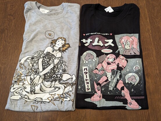 Two t-shirts on a table.

The left one is a gray The Legend of Zelda: Tears of the Kingdom-themed shirt featuring Princess Zelda holding the decayed Master Sword.

The right one is a black Metroid-themed shirt featuring Samus Aran in Power Armor and a few Metroids.