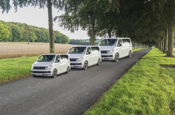 Photo of a road with three vans, they’re the same size but the road tricks the eye into thinking they’re different sizes. 