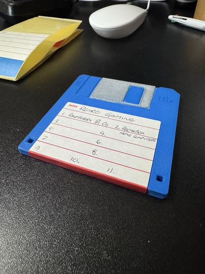 MicroSD card holder disguised as a 3.5” floppy disk with a label on the front. It says “Retro Gaming” as the title. 1. Raspberry Pi OS, 2. Recalbox (Home Computers).

There are spaces for up to 11 items on the label but the rest are blank.