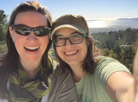 A picture of two women looking at the camera in a selfie photograph smiling with the view of Berkeley in the background 