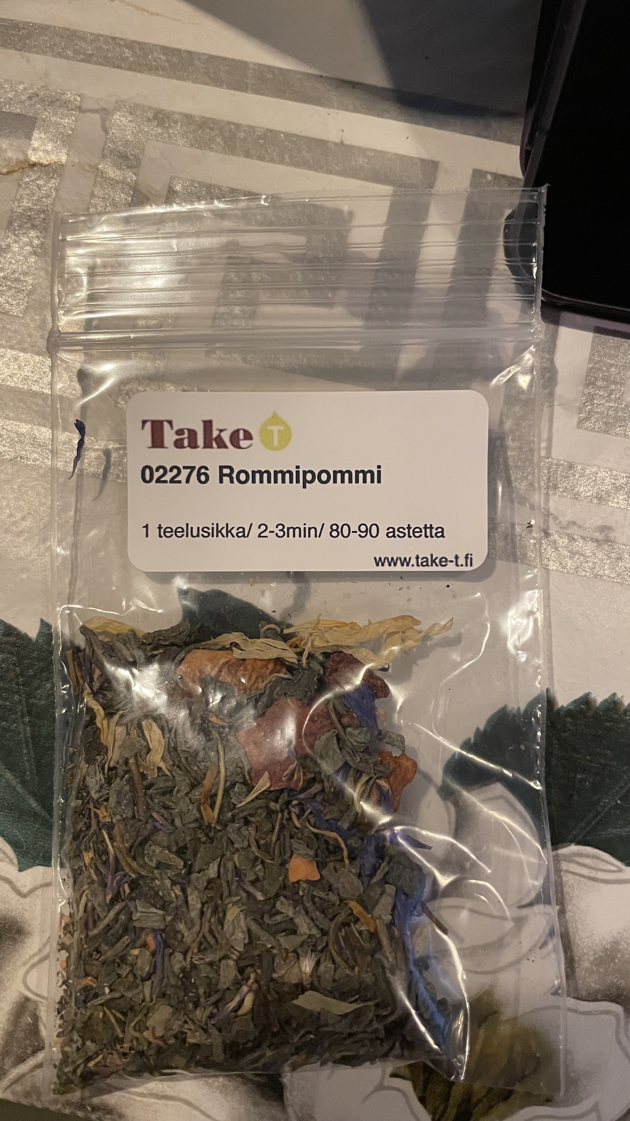 A small ziplock bag with tea leaves in it. The label on top states the names of the tea shop and the tea blend. It also gives brewing instructions in Finnish.